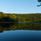 The river is calm and the sun is starting to go down.